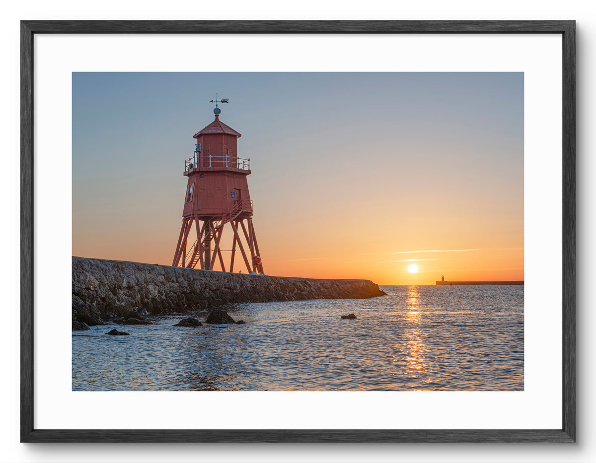 Herd Groyne Lighthouse - Sun reflecting on Sea - South Shields shown as a framed photographic print.
