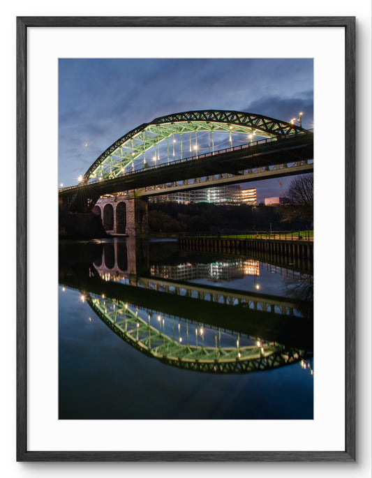 Wearmouth Bridge - Reflecting on a Still River Wear - Sunderland shown as a framed photographic print.