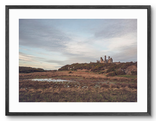 Dunstanburgh Castle on the Northumberland coast shown as a framed photographic print.