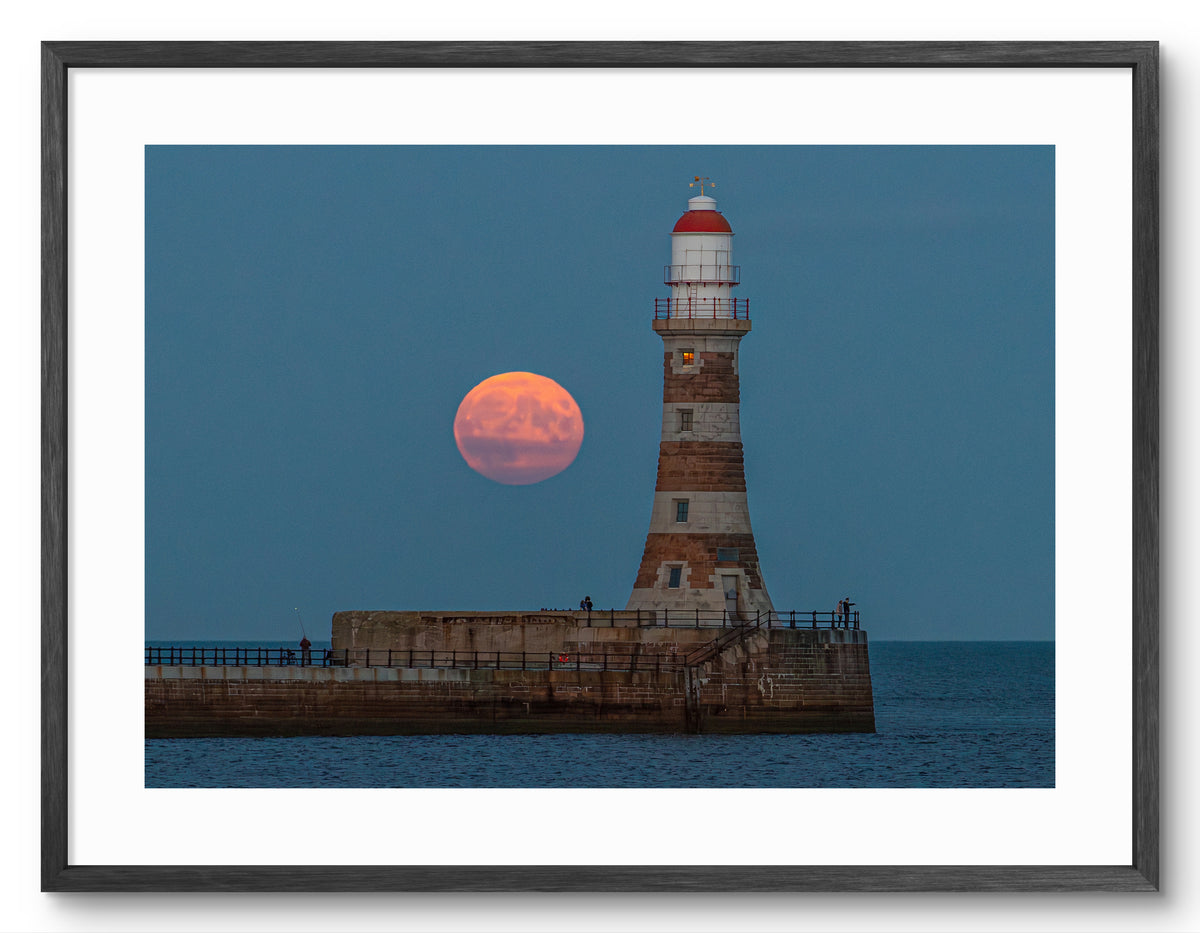 Roker Pier Lighthouse - Harvest Moon - Sunderland shown as a framed photographic print.