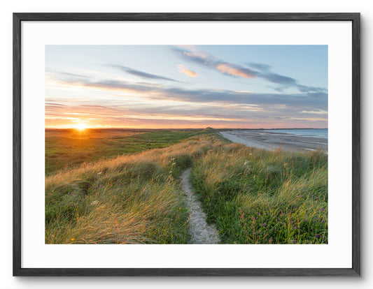 Sunset over grassy dunes at Druridge Bay shown as a framed photographic print.