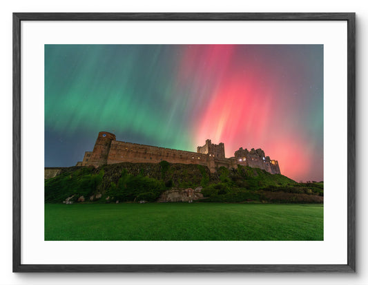 Bamburgh Castle under the Aurora Borealis shown as a black framed print.