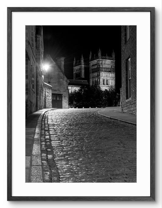 Durham Cathedral - Black and White - Cobbled Road shown as a framed photographic print.