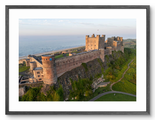 Aerial view of Bamburgh Castle and the Northumberland coast shown as a framed photographic print.