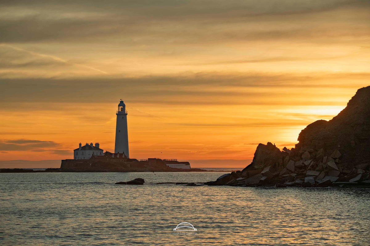 St Mary’s Lighthouse on its island at sunrise, with the rocky Whitley Bay coastline.