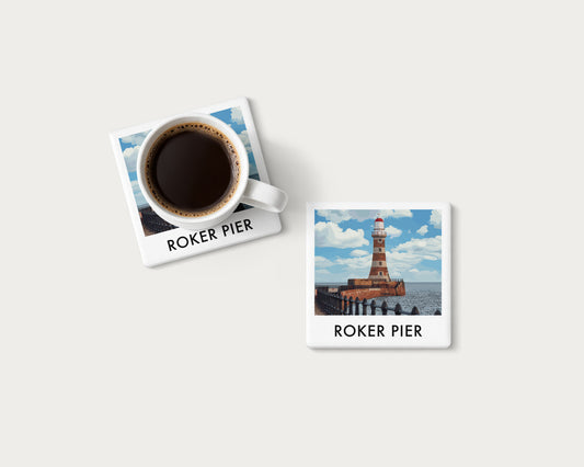 Illustrated ceramic coaster showing Roker Pier lighthouse and railings beneath a blue sky; mockup with a coffee mug.