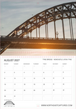 A printed or digital August 2027 calendar page featuring a large photograph of Tyne Bridge in Newcastle upon Tyne at sunset. The top portion shows the bridge against a warm sky, while the bottom portion contains the calendar grid with days of the week, title text, and website branding.
