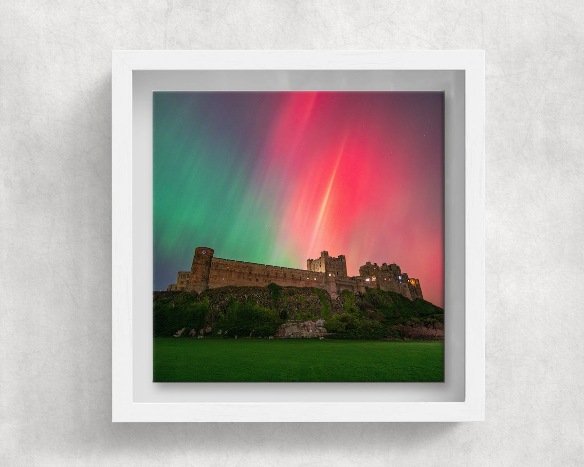 Bamburgh Castle Northern Lights on an 8×8 inch ceramic tile in a white box frame, front view
