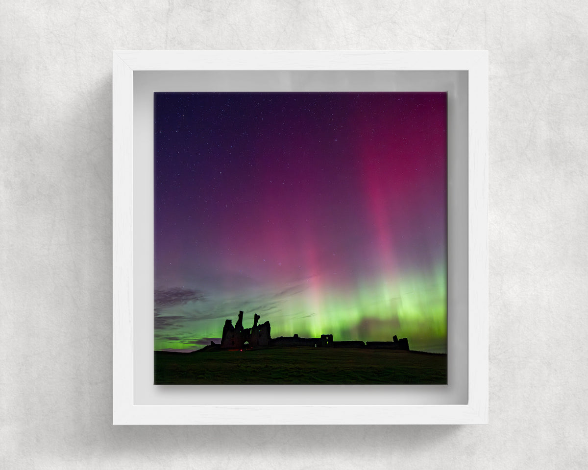 Dunstanburgh Castle Northern Lights on an 8×8 inch ceramic tile in a white box frame, front view