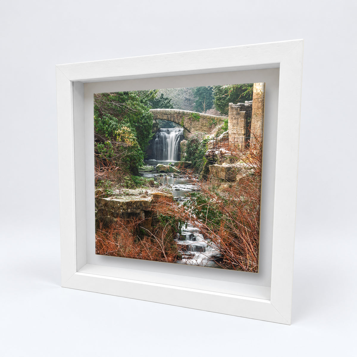 Jesmond Dene Waterfall on an 8×8 inch ceramic tile in a white box frame, angled view