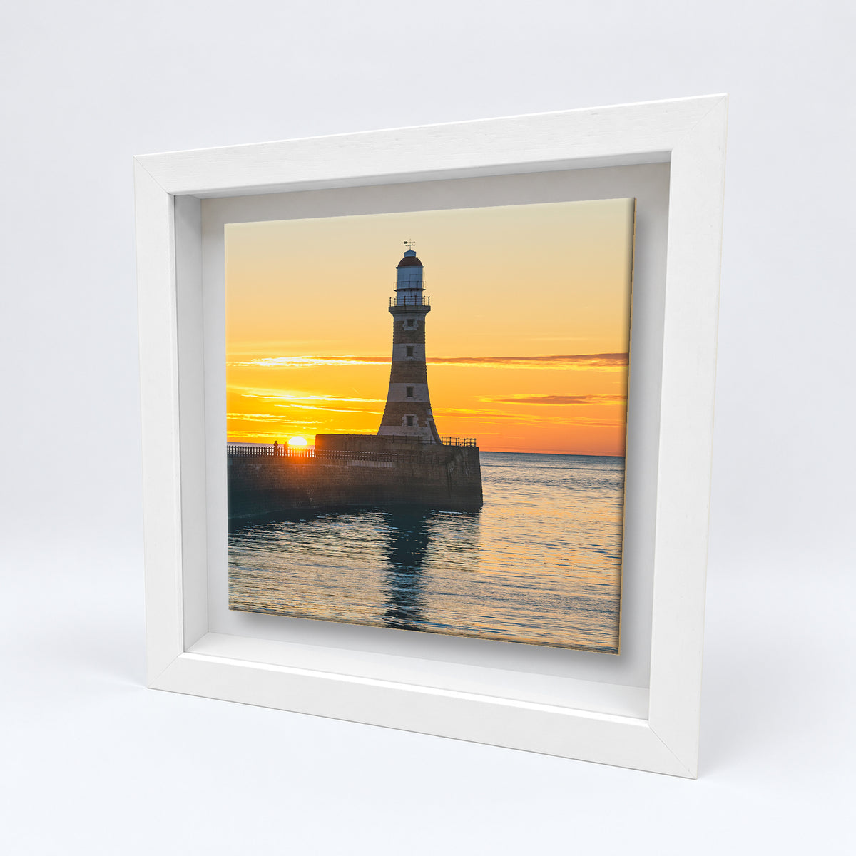 Roker Lighthouse Sunrise on an 8×8 inch ceramic tile in a white box frame, angled view