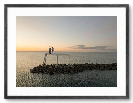 The Couple Sculpture Sunset — black frame with white mount