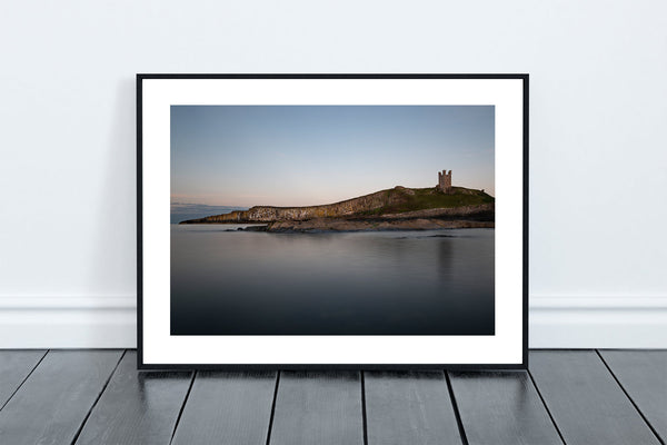 Lilburn Tower at Dunstanburgh Castle, perched on the dolerite rocks of the Great Whin Sill reflecting in the calm North Sea. - North East Captures