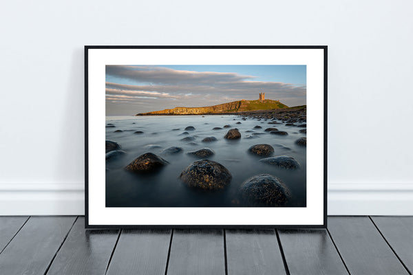 Boulder Beach, Death Rocks looking towards The Lilburn Tower at Dunstanburgh Castle perched on the dolerite rocks of the Great Whin Sill. - North East Captures